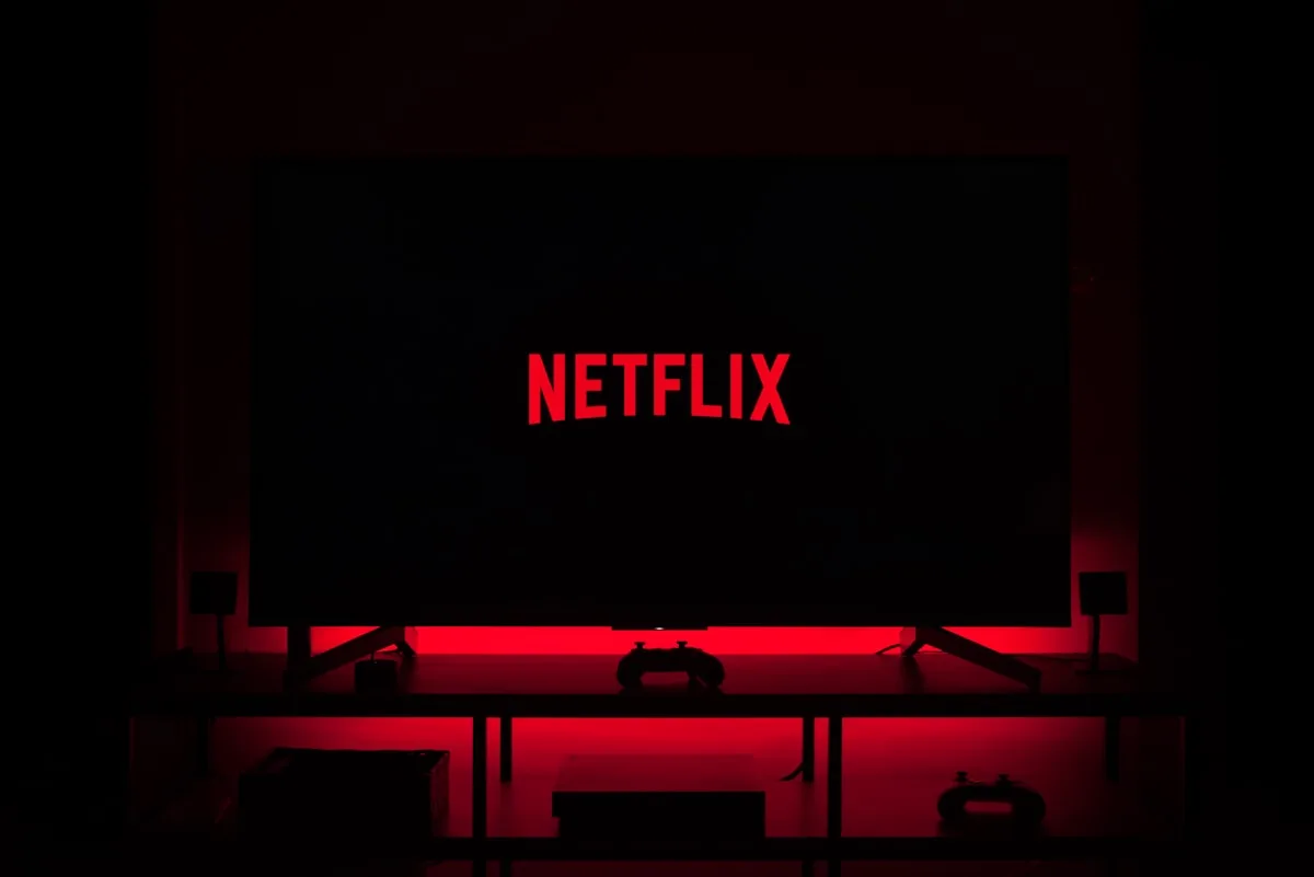Person using a TV remote control watching streaming content on a smart TV